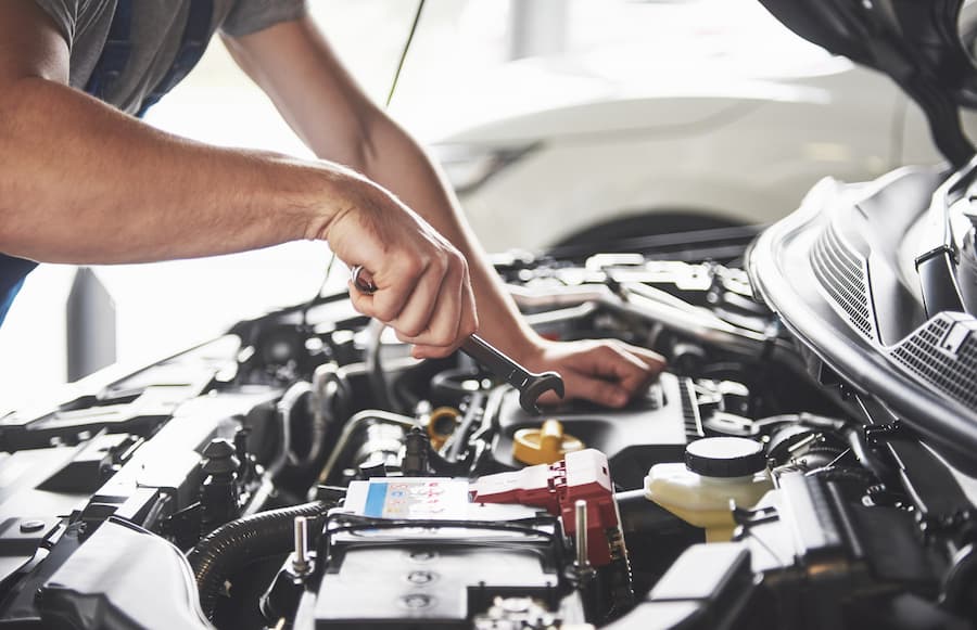 muscular-car-service-worker-repairing-vehicle (1)